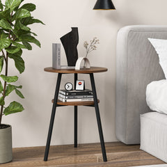 The side table placed next to a bed with books and a decorative sculpture on the shelves