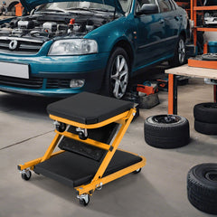 Yellow and black rolling creeper seat positioned next to a car with its bonnet open