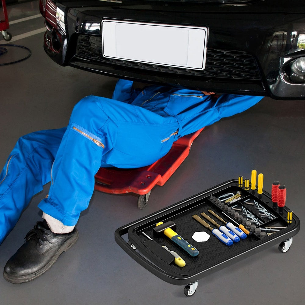 Mechanic using the rolling tool tray with detachable part tray under a car