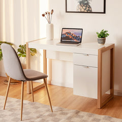 White computer desk with a laptop and a chair in a home office setting