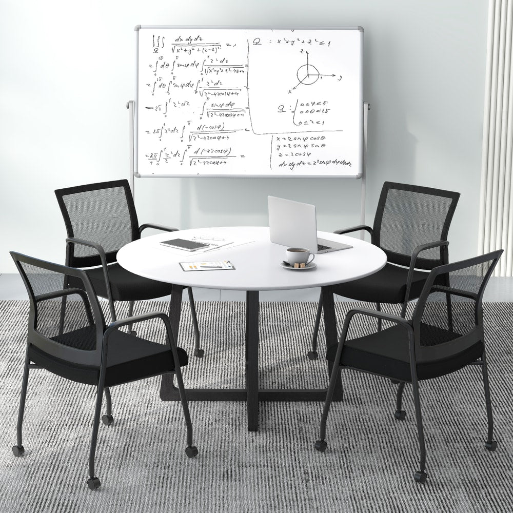The office chairs arranged around a round meeting table in a bright workspace