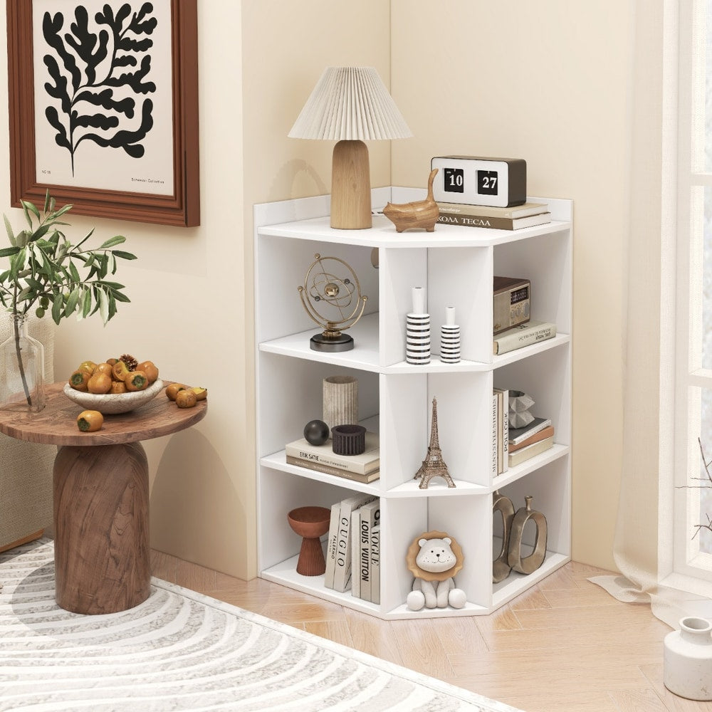 The white corner cabinet styled in a living room corner with a lamp and ornaments on shelves