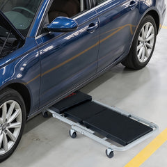 The flat mechanic creeper positioned underneath the side of a car for maintenance access