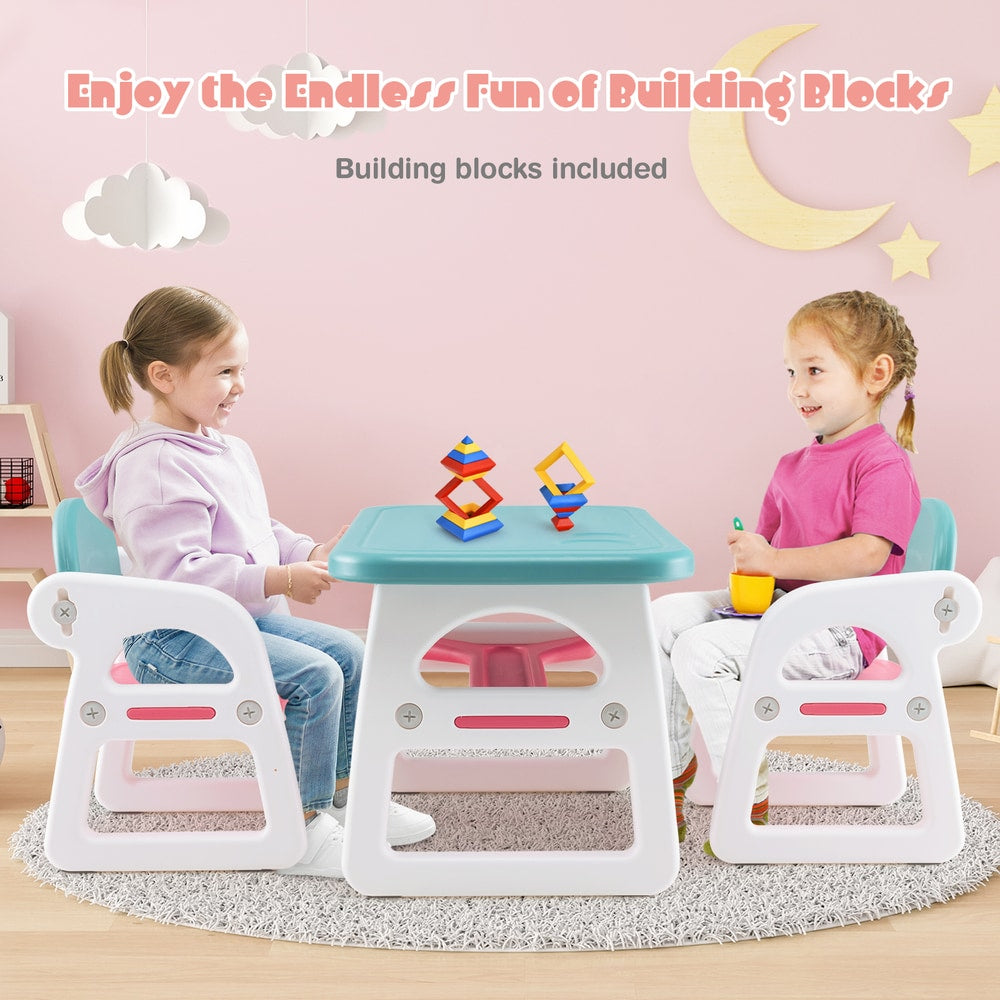 Two children sitting at the kids table and chair set playing with building blocks