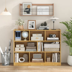 A yellow wooden bookcase filled with books, decorative items and a globe