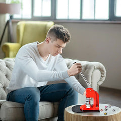 A man using the badge making machine to create a pin button in a living room setting