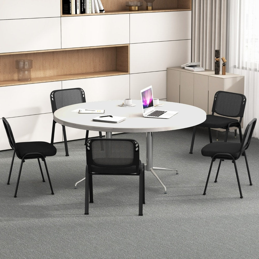 The office chairs placed around a round meeting table in a bright modern office space