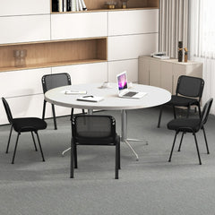 The office chairs placed around a round meeting table in a bright modern office space