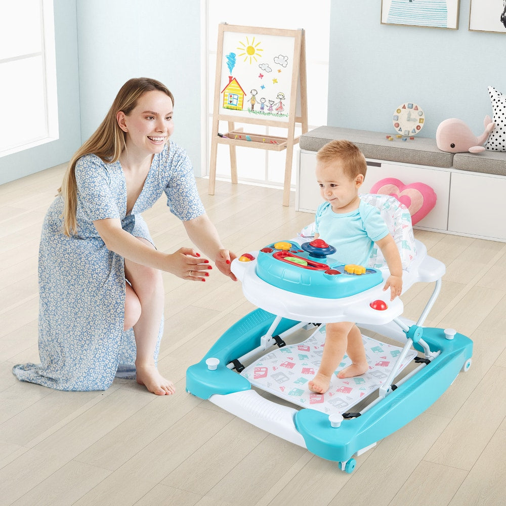 A mother watches her baby in the green baby walker activity center in a living room