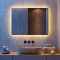 The lighted bathroom mirror above a stone basin in a contemporary room with tiled walls