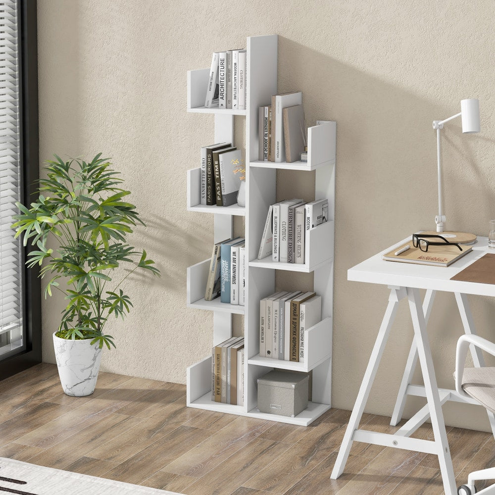 The white bookcase standing in a home office next to a desk and a green plant