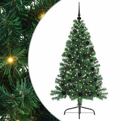 Close up of the green artificial Christmas tree branches with lights and baubles