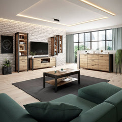 A modern living room furniture set featuring light oak wood and black metal pieces, including a coffee table, media console, sideboard, and tall bookshelves, arranged in a bright living room with a brick wall and large windows.