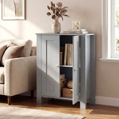 The freestanding wooden storage cabinet in grey in a living room setting with books and a vase