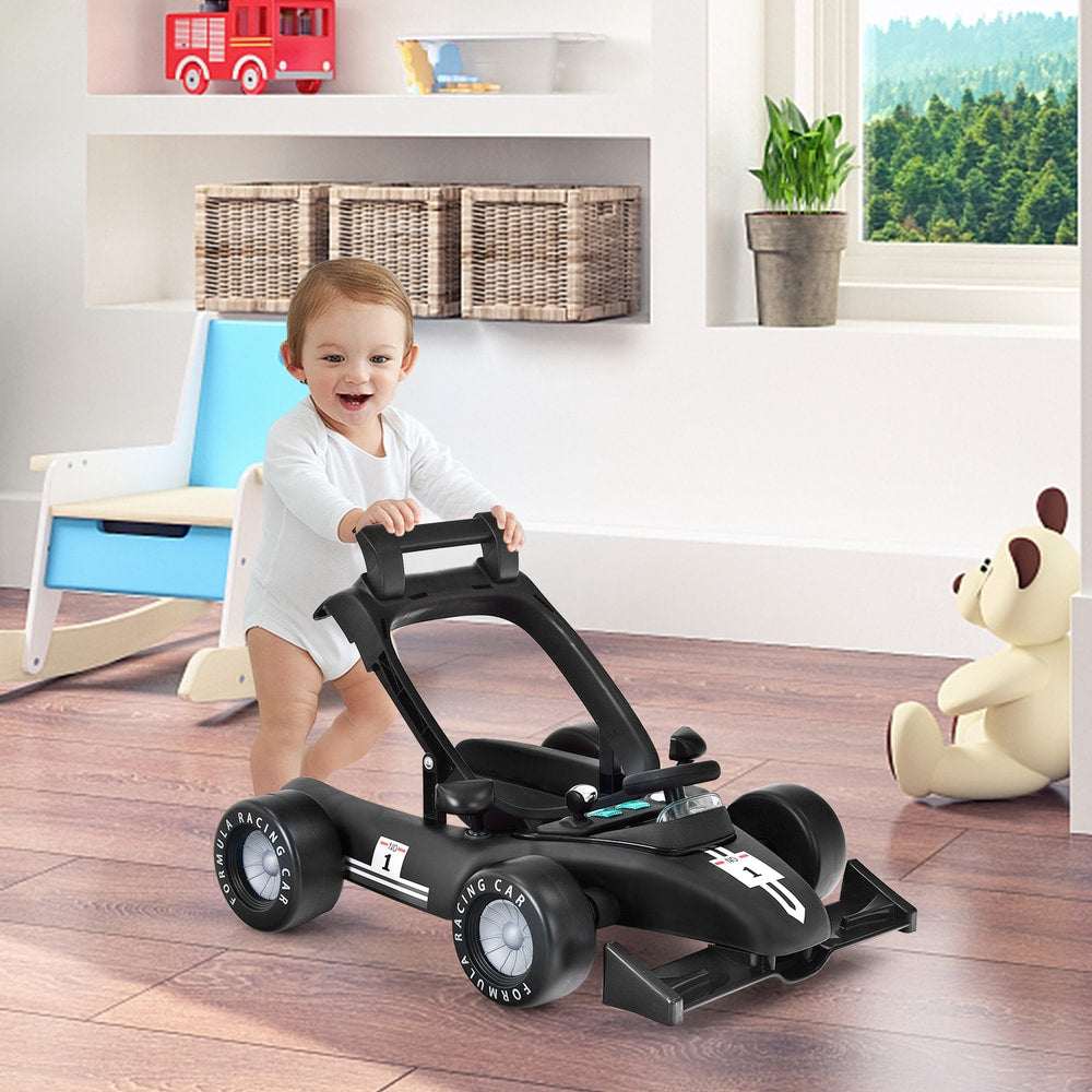 Baby push walker in black, with a baby standing behind it