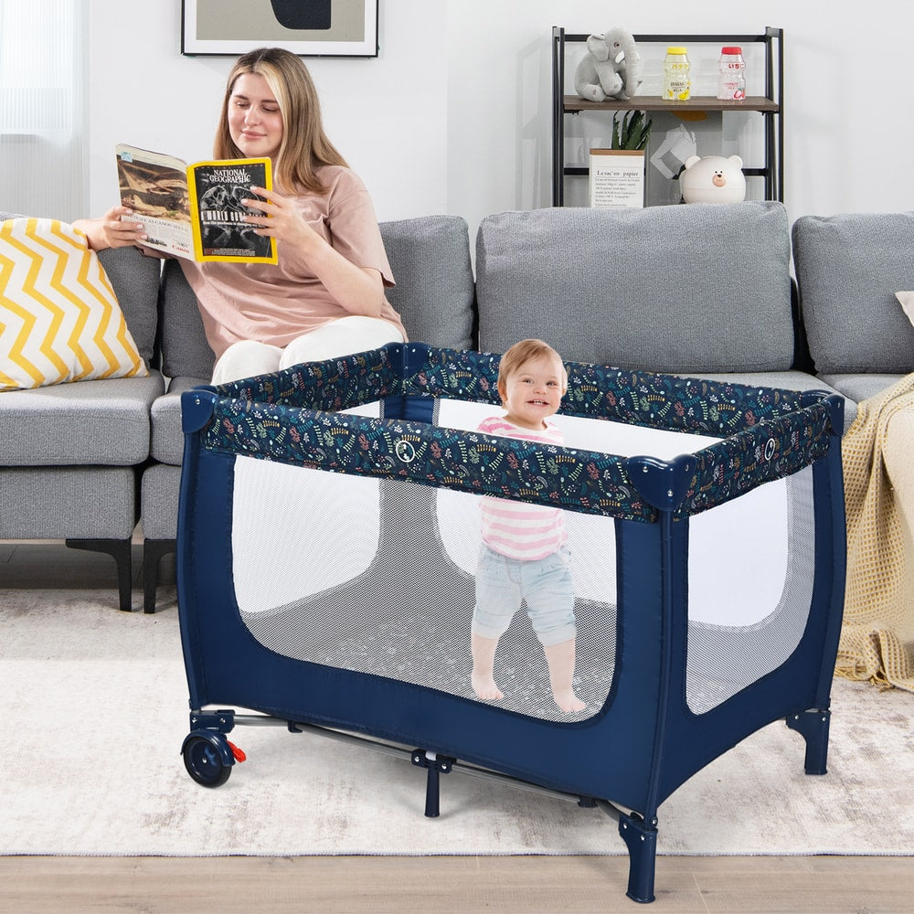 Child standing inside the blue baby playpen in a living room