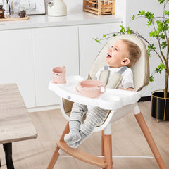 Happy baby sitting in the beige Baby High Chair in a kitchen