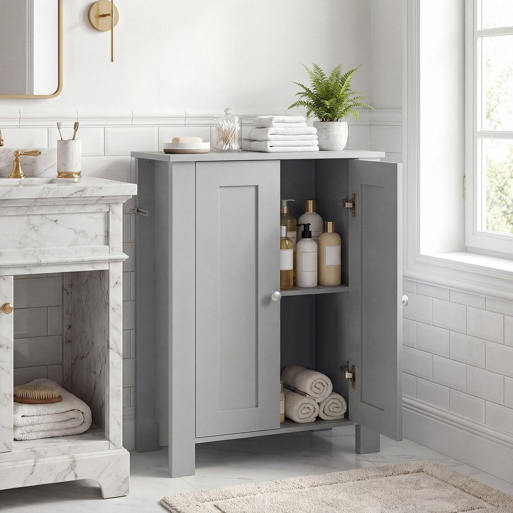 The grey bathroom cabinet with its double doors open showing two shelves with towels and bottles