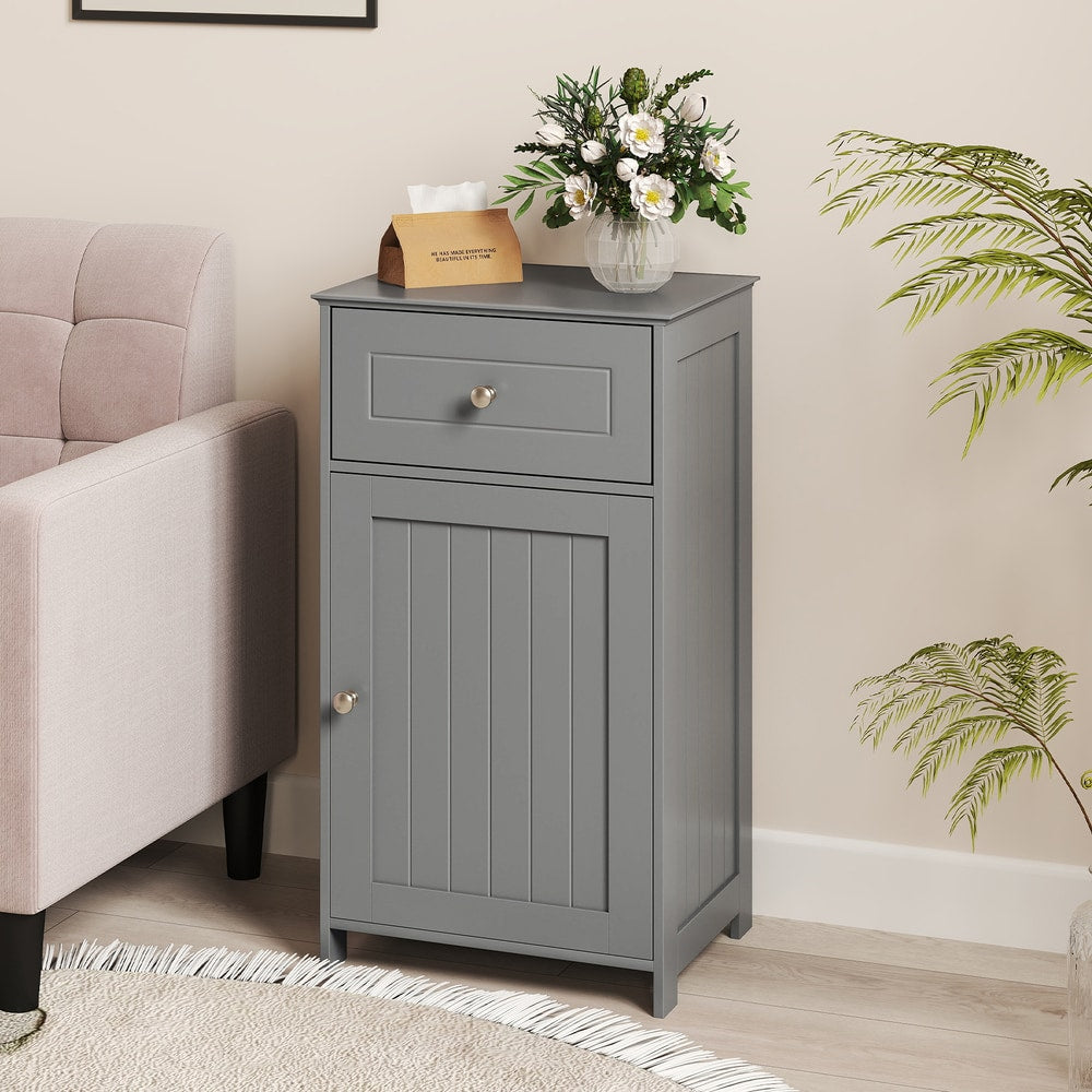 The floor cabinet placed in a living room next to a sofa with a flower vase on top