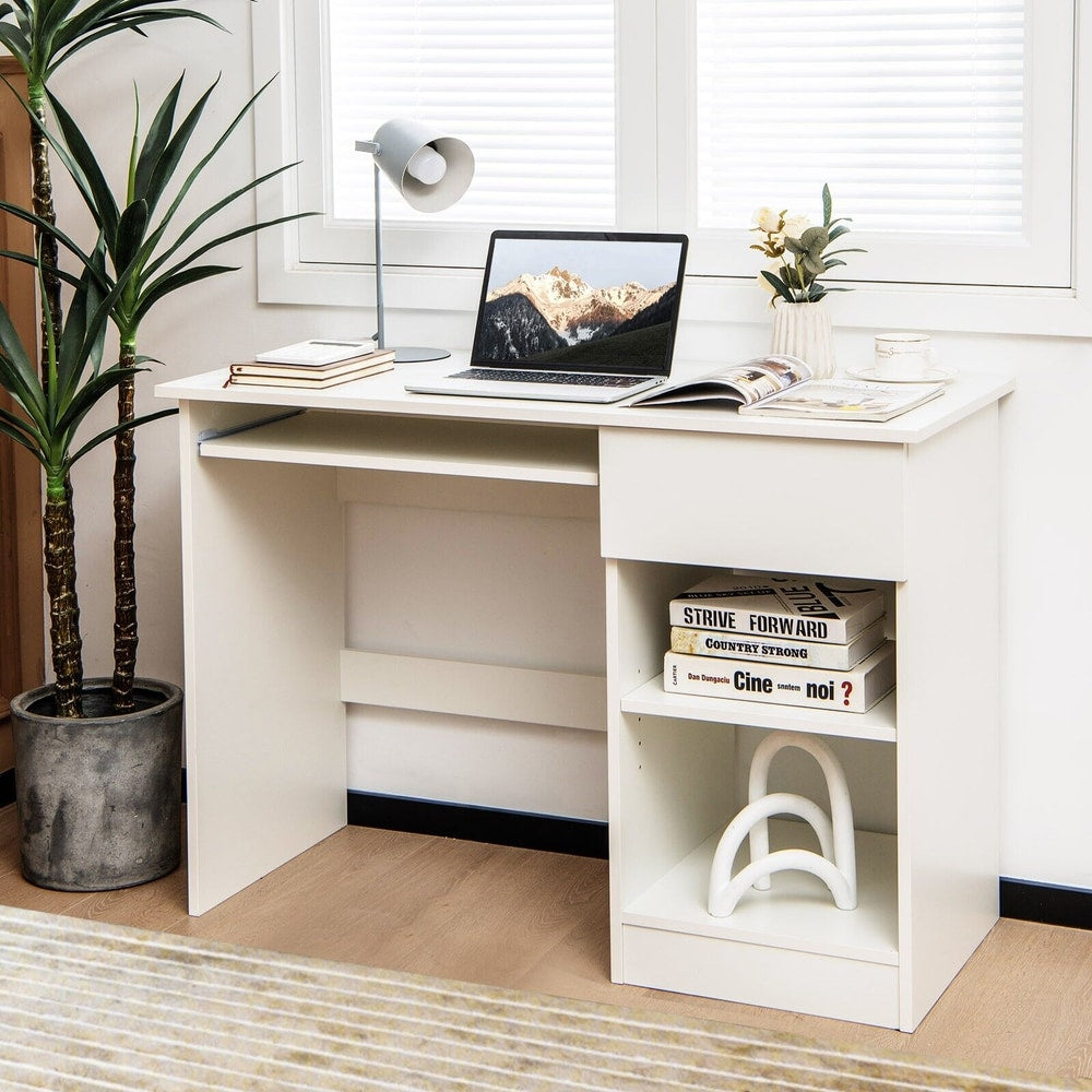 White computer desk with a laptop on the keyboard tray, set up in a room