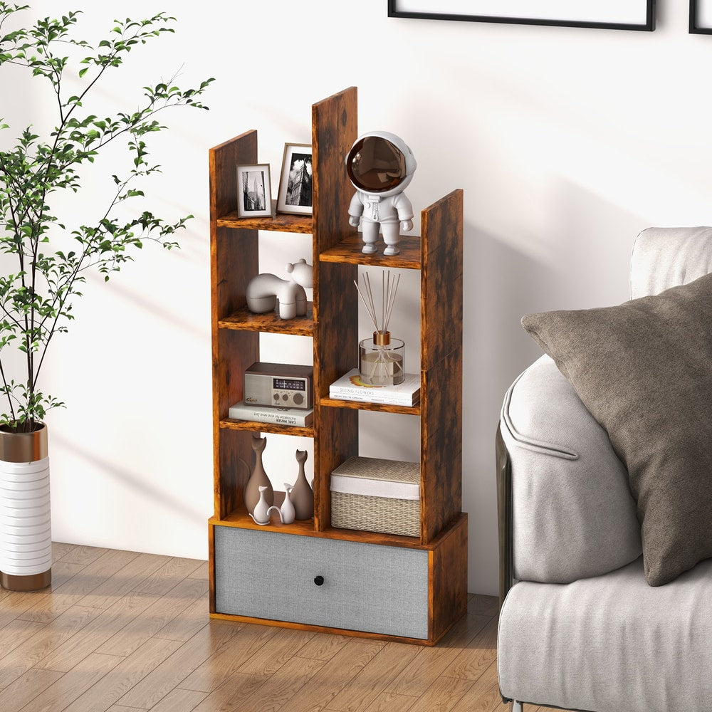 Rustic brown wooden bookshelf with a grey fabric drawer, styled in a living room setting