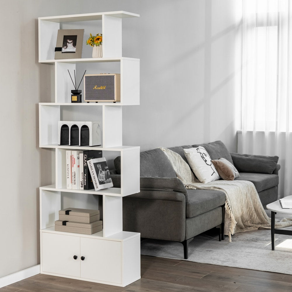 The white bookcase with cabinet in a living room next to a sofa