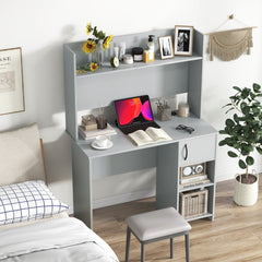 The office desk placed in a bedroom setting with a tablet and books on the work surface