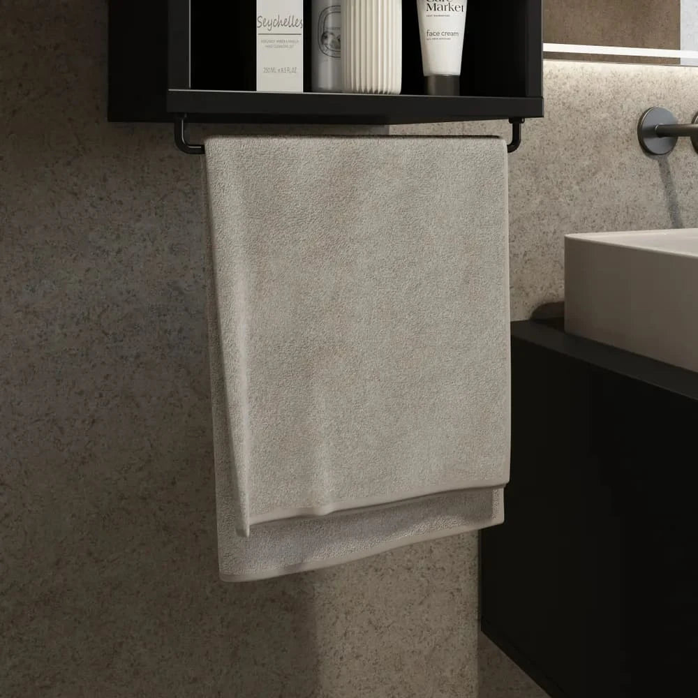 The bathroom cabinet towel rail with a grey towel hanging below the open storage shelf