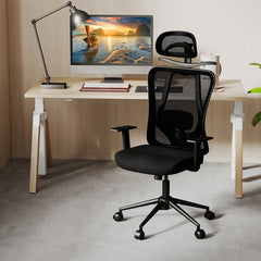The office chair positioned in front of a wooden desk with a computer monitor in a home office