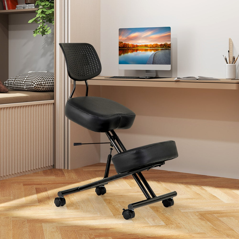 The black posture correction stool in a home office setting with a computer and plant