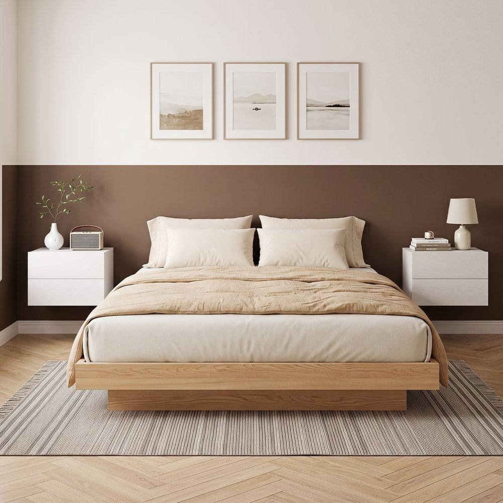 Two white floating bedside tables mounted on a wall either side of a bed