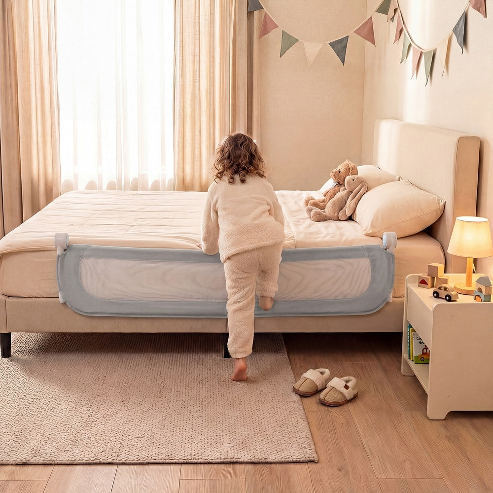 The bed rail in a lowered position while a child climbs onto the bed