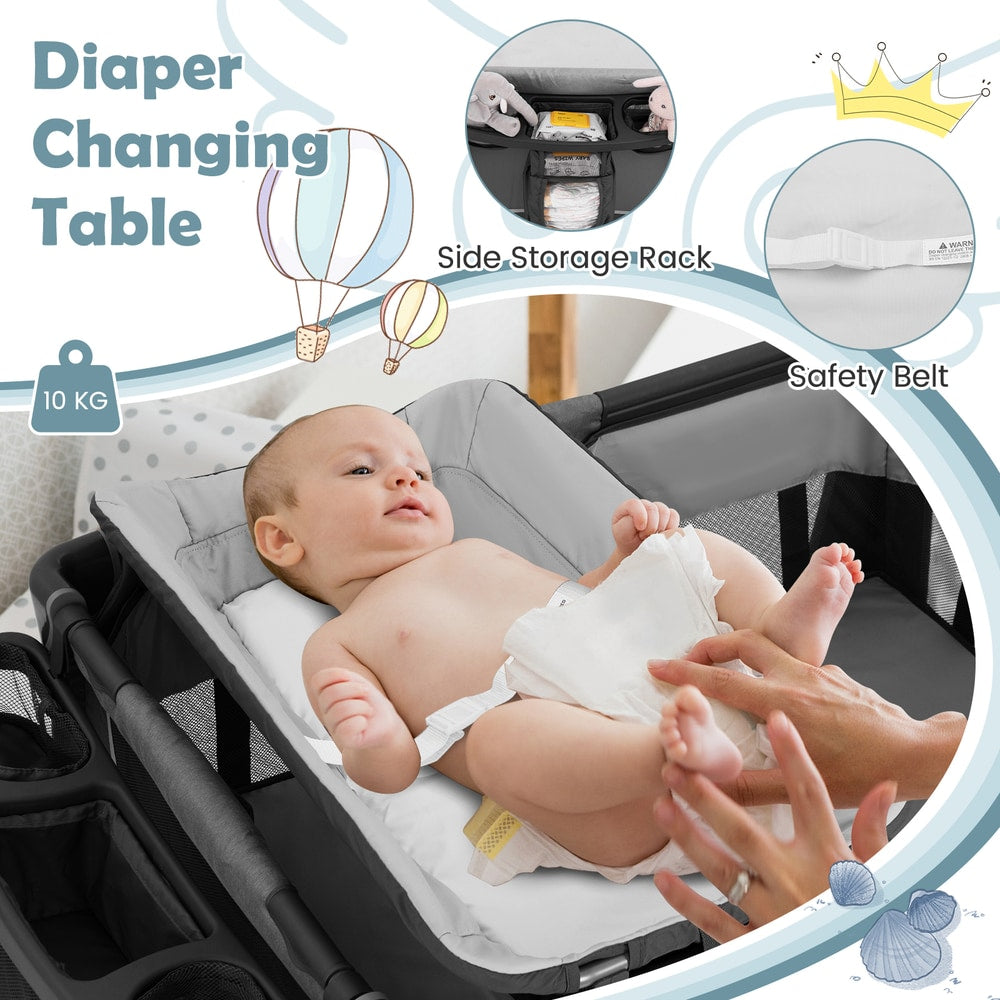 Baby lying on the changing table attachment of the foldable pack and play, with side storage and safety belt