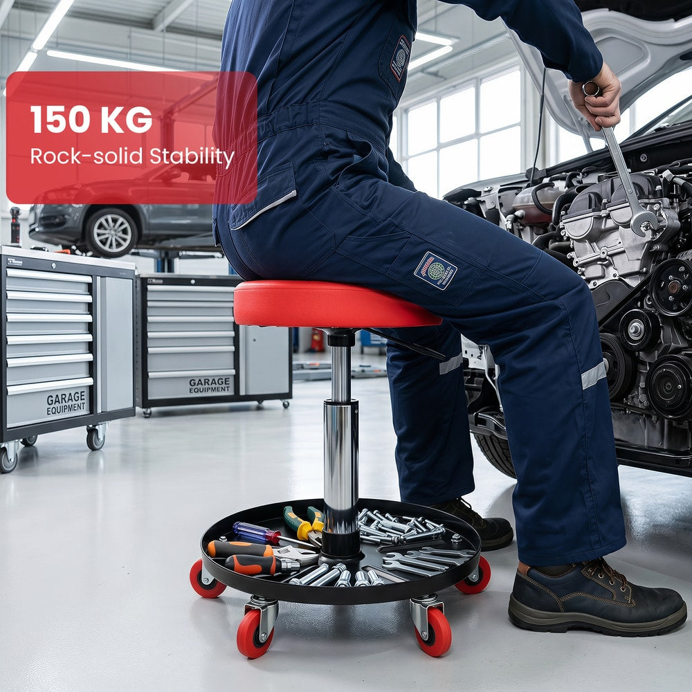 Man working on a car engine while sitting on the red mechanic stool