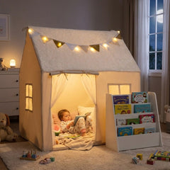The playhouse and bookshelf in a bedroom at night with the star lights glowing and a child reading