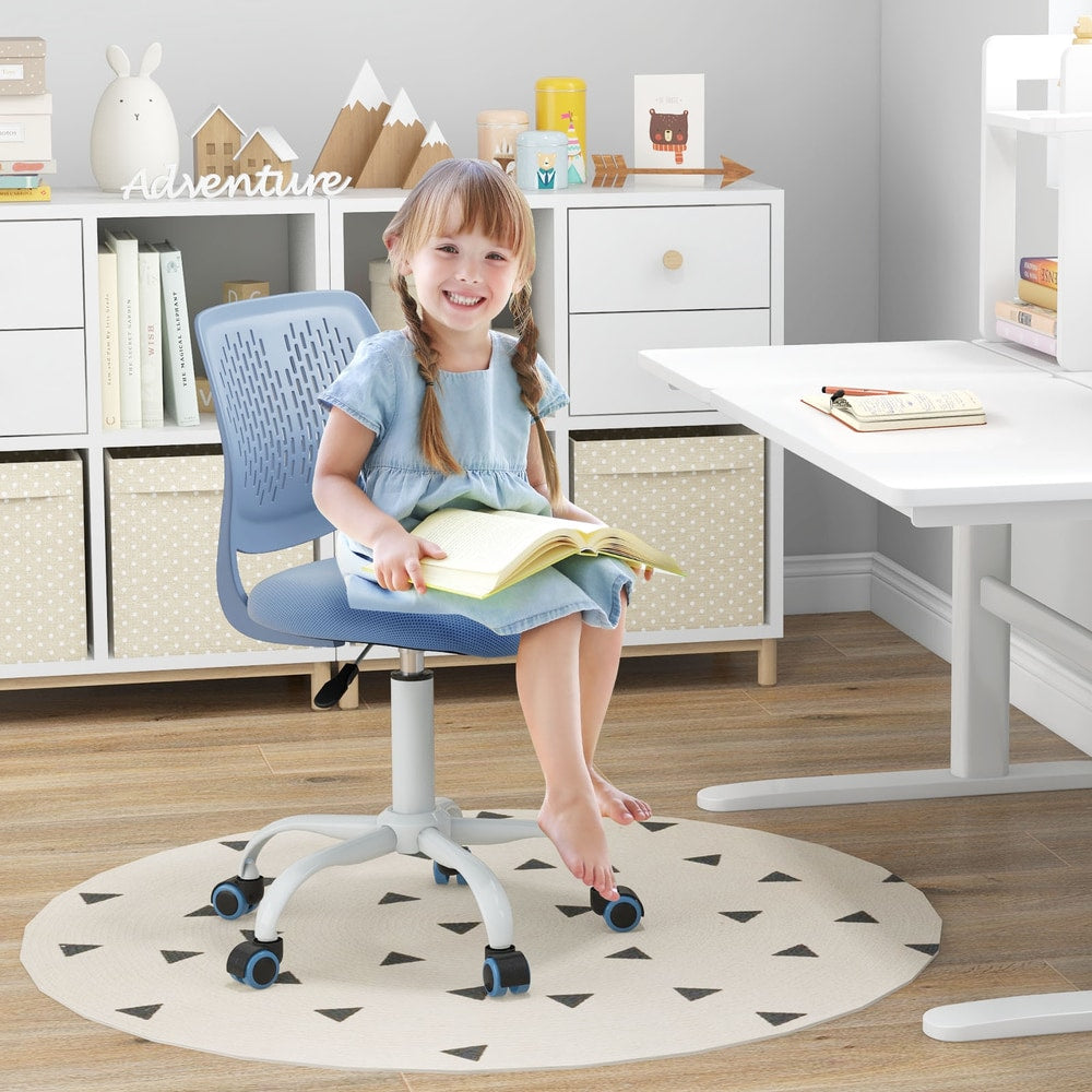 The kids chair being used by a young girl sitting at a white desk reading a book in a bedroom