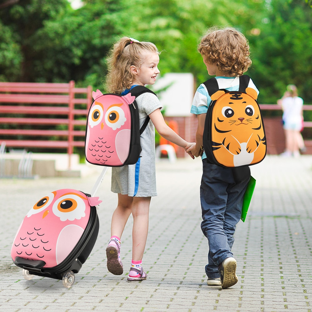 A girl pulls a pink owl suitcase while a boy wears a tiger backpack
