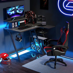 The office desk in a dark room with blue neon lighting and a gaming chair