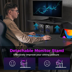 The office desk with a person sitting at it showing the benefit of the monitor shelf