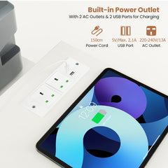 The office desk surface featuring a built-in power outlet with charging ports for devices