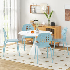 Four blue metal dining chairs placed around a white dining table in a bright room