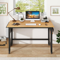 The natural wood computer desk with a computer and plant in a bright room setting