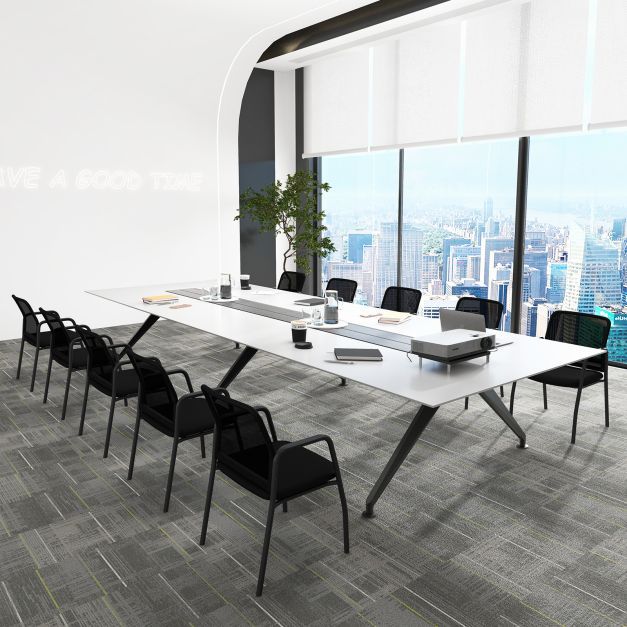 A long conference table with multiple black office chairs in a bright, modern room