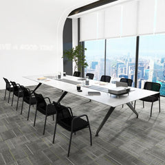 A long conference table with multiple black office chairs in a bright, modern room