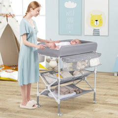 The changing table in a nursery with a mother changing her baby on the padded surface