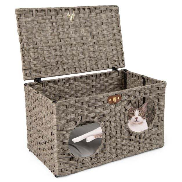 Close up of the rattan cat house with a cat peeking out of the entrance hole