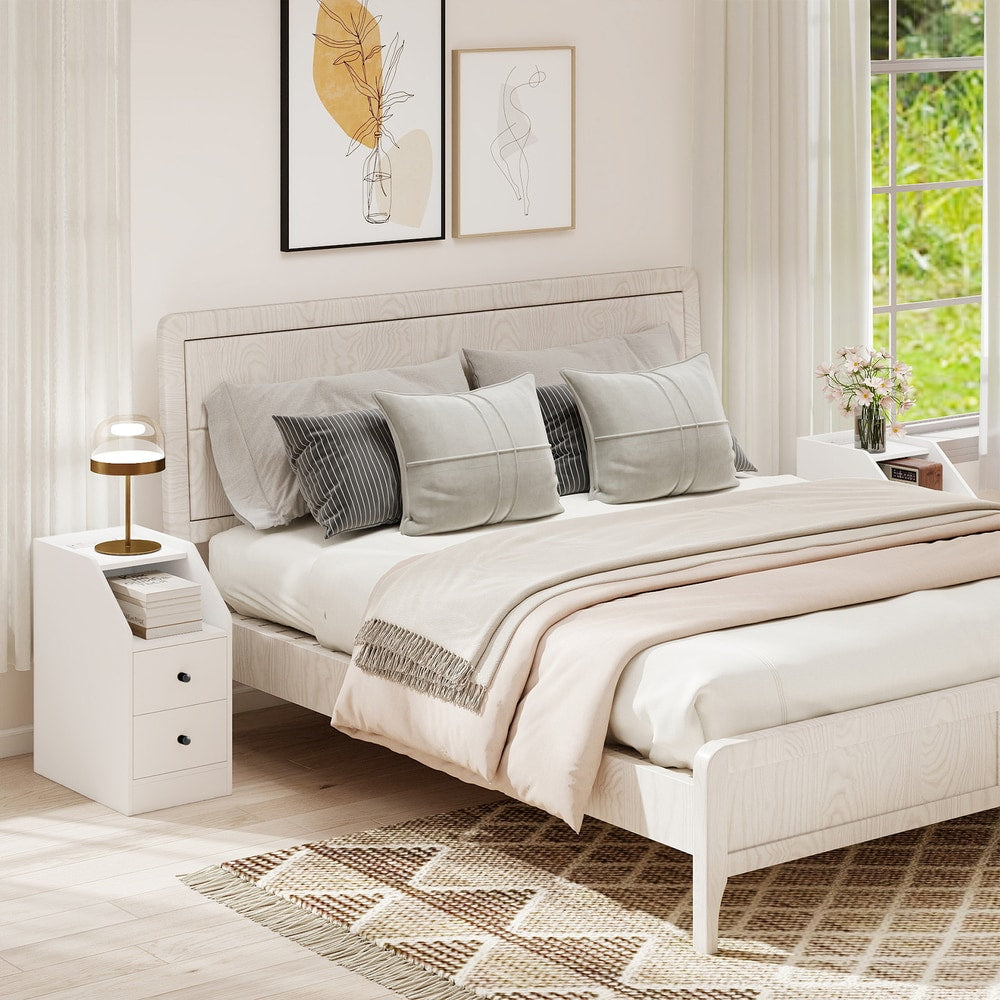 The white end table placed next to a bed in a bright and modern bedroom setting