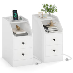 The white end tables styled with books, plants and a phone charging on the top surface