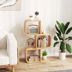 The bamboo bookshelf placed in a bright living room next to a white sofa and a large green plant