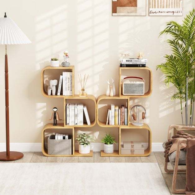 Two of the bamboo bookcases placed side by side against a wall with books and ornaments on shelves